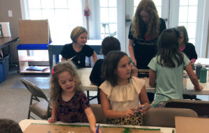 photo of children painting baffles for use in Habitat for Humanity built homes.